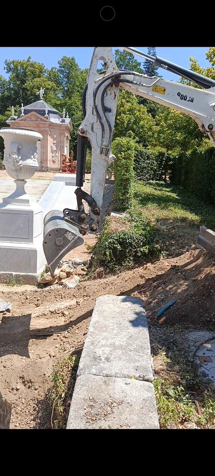 Excavadora trabajando junto a zona ajardinada